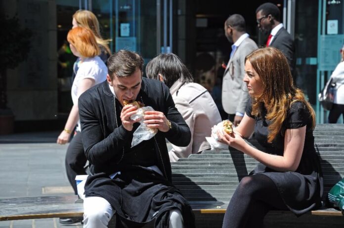 Couple sitting on a bench having a takeaway lunch