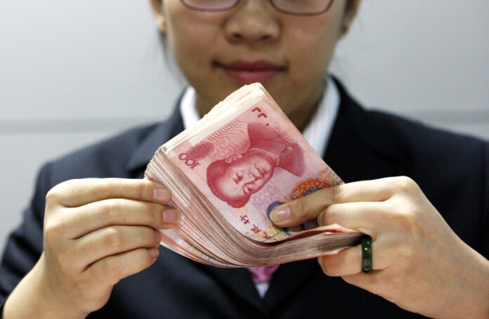 A Chinese clerk counts RMB (renminbi) yuan banknotes at a bank in Huaibei