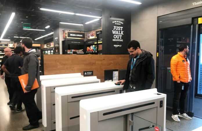 A shopper scans a smartphone app associated with his Amazon account and credit card information to enter the Amazon Go store in Seattle