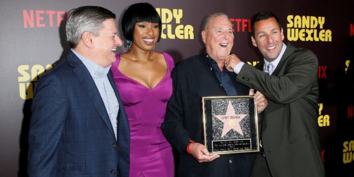 Netflix Chief Content Officer Ted Sarandos actors Jennifer Hudson and Adam Sandler present a gift to talent manager Sandy Wernick at a premiere for the Netflix original film Sandy Wexler in Los Angeles