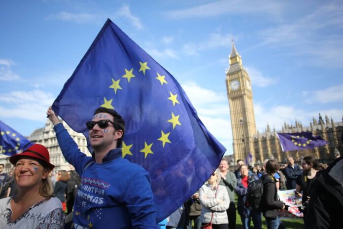 Central London, Uk. 25 March, 2017 A man holds an EU flag aloft at an anti-Brexit rally with Big Ben in the background.