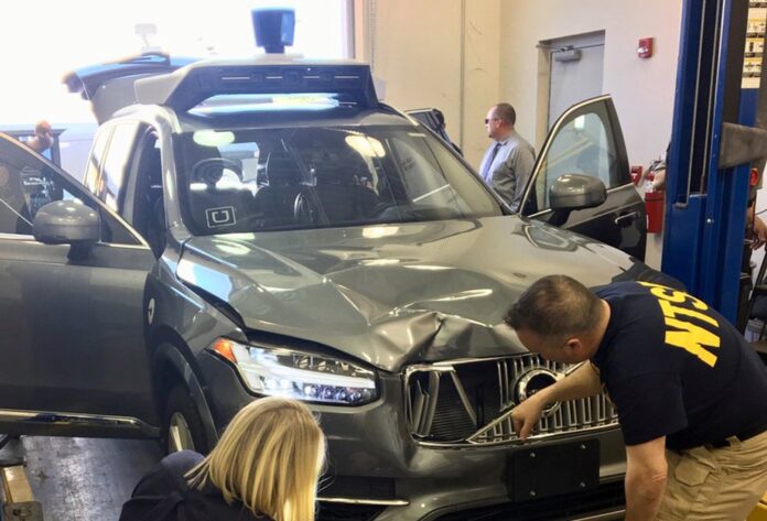 NTSB investigators examine a self-driving Uber vehicle involved in a fatal accident in Tempe