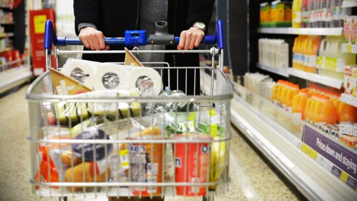 A shopper browses an aisle of a Tesco supermarket store