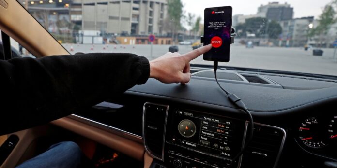 An engineer points to a Huawei Mate 10 Pro mobile used to control a driverless car during the Mobile World Congress in Barcelona.